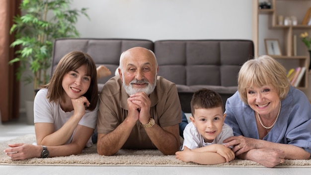 Famiglia felice del colpo completo che pone sul pavimento