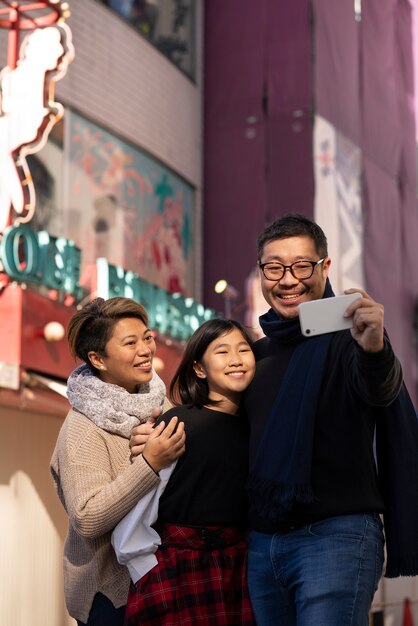 Famiglia felice del colpo medio che prende selfie