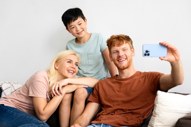 Famiglia felice del colpo medio che prende selfie