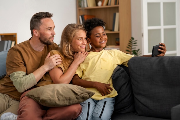 Famiglia felice del colpo medio che prende selfie