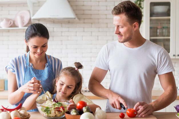 Famiglia felice di vista frontale che cucina insieme