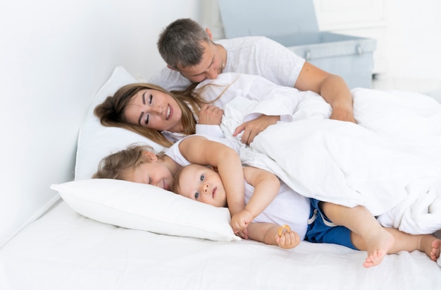 Famiglia felice di vista laterale che si situa a letto