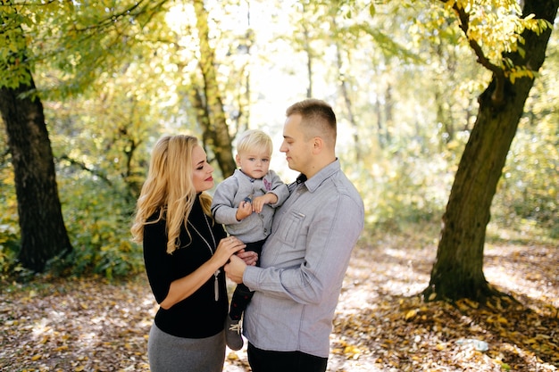 famiglia felice giocando e ridendo nel parco in autunno