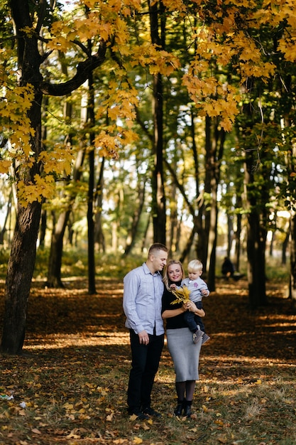 famiglia felice giocando e ridendo nel parco in autunno