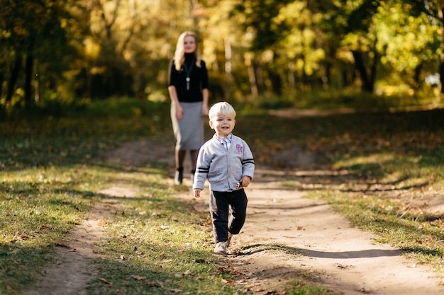 famiglia felice giocando e ridendo nel parco in autunno