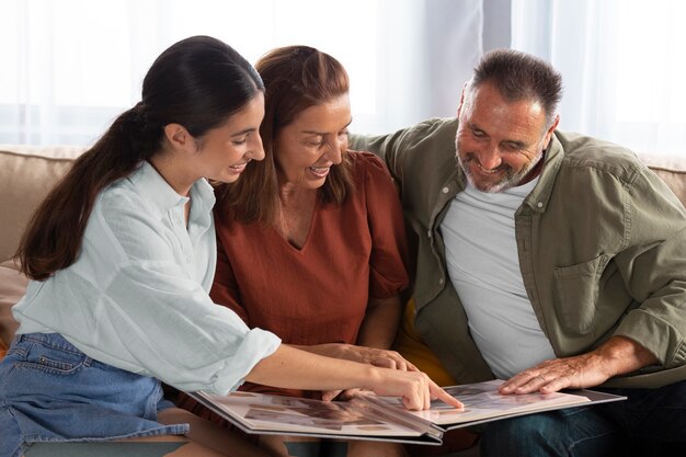 Famiglia felice guardando il tiro medio dell'album di foto