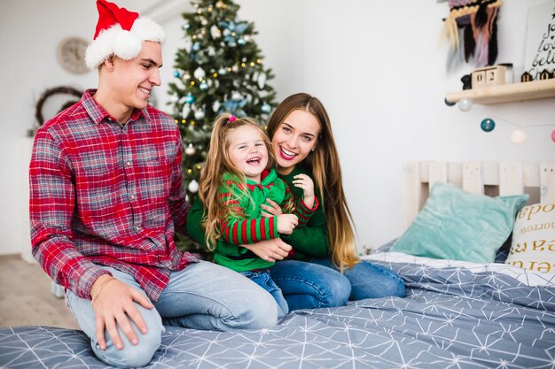 Famiglia felice sul letto a Natale