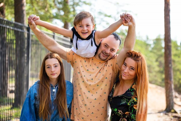 Famiglia felice sulla posa della natura contro la foresta