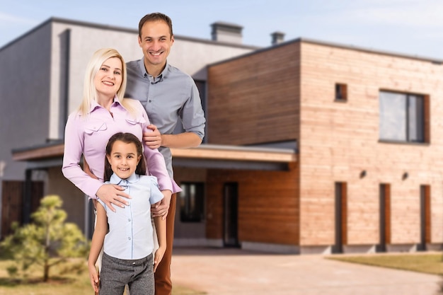 Famiglia felice vicino alla nuova casa. Concetto di bene immobile.