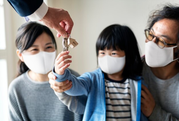 Famiglia giapponese in maschera che compra una nuova casa