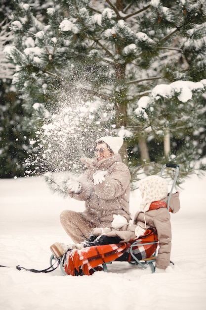 Famiglia in abiti invernali in vacanza nel bosco innevato