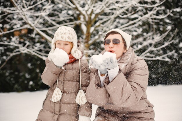 Famiglia in abiti invernali in vacanza nel bosco innevato