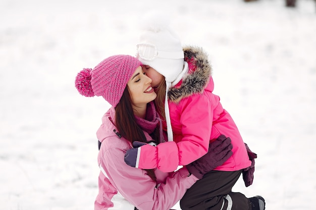 Famiglia in cappelli invernali lavorati a maglia in vacanza di Natale in famiglia. Donna e bambina in un parco. Persone che giocano.