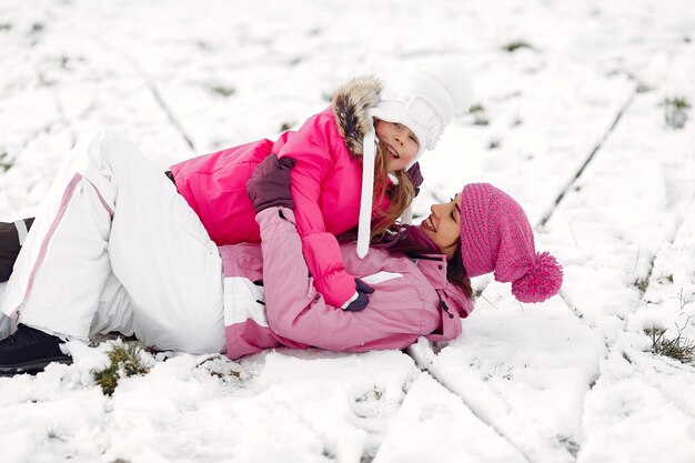 Famiglia in cappelli invernali lavorati a maglia in vacanza di Natale in famiglia. Donna e bambina in un parco. Persone che giocano.