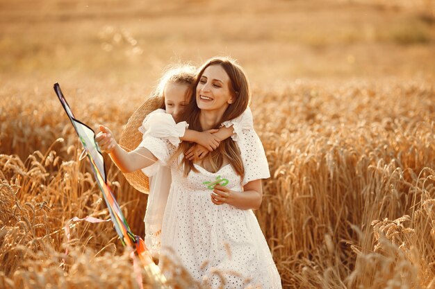 Famiglia in un campo di grano. Donna in abito bianco. Piccolo bambino con l'aquilone.