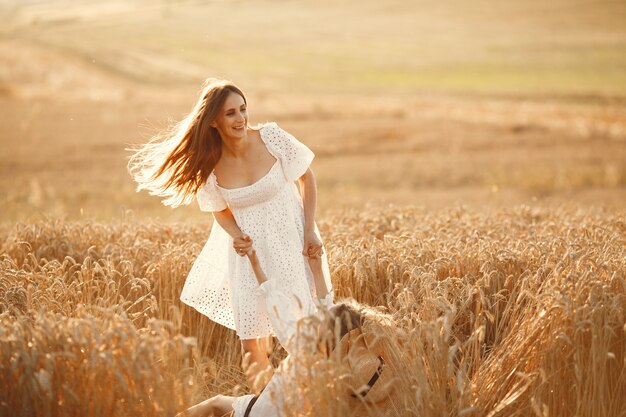 Famiglia in un campo di grano. Donna in abito bianco.