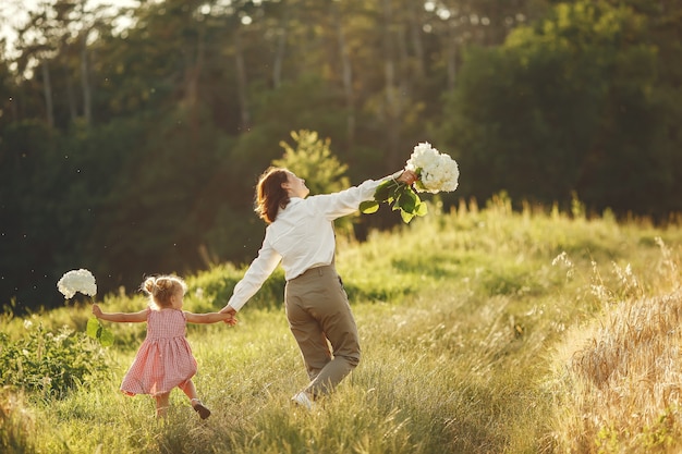 Famiglia in un campo estivo. Foto sensuale. Piccola ragazza carina.