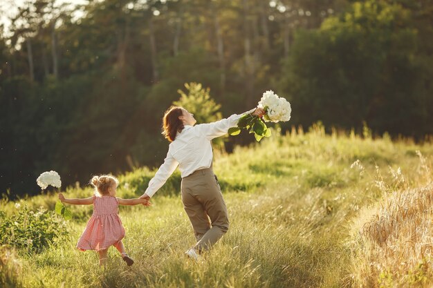 Famiglia in un campo estivo. Foto sensuale. Piccola ragazza carina.