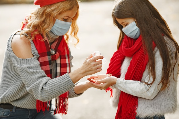 Famiglia in un parco d'autunno. Tema Coronavirus. Madre con figlia. Le persone usano l'antisettico.