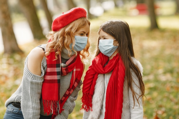 Famiglia in un parco d'autunno. Tema Coronavirus. Madre con figlia.