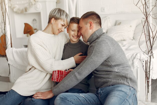 Famiglia in una stanza. Ragazzino vicino alla decorazione di Natale. Madre con padre con figlio