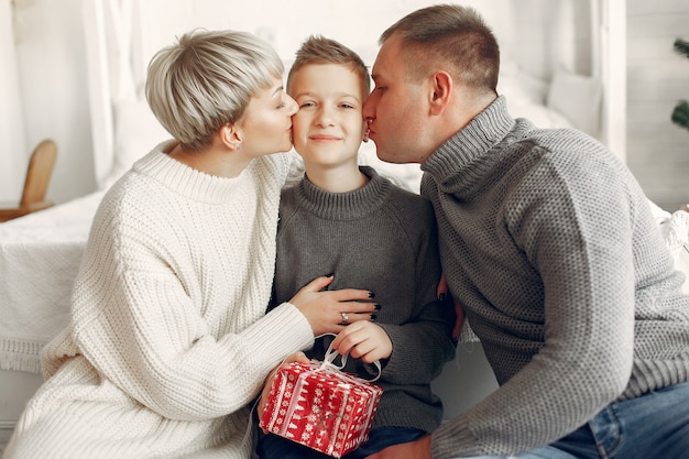 Famiglia in una stanza. Ragazzino vicino alla decorazione di Natale. Madre con padre con figlio