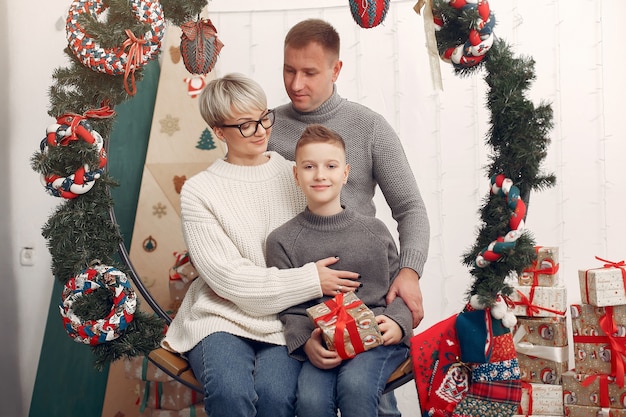 Famiglia in una stanza. Ragazzino vicino alla decorazione di Natale. Madre con padre con figlio