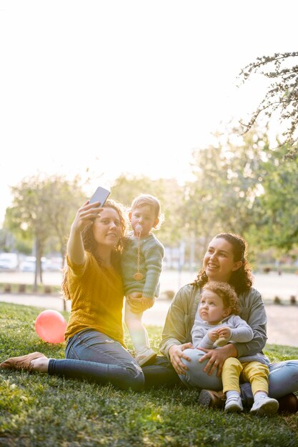 Famiglia LGBT all'aperto nel parco prendendo un selfie insieme