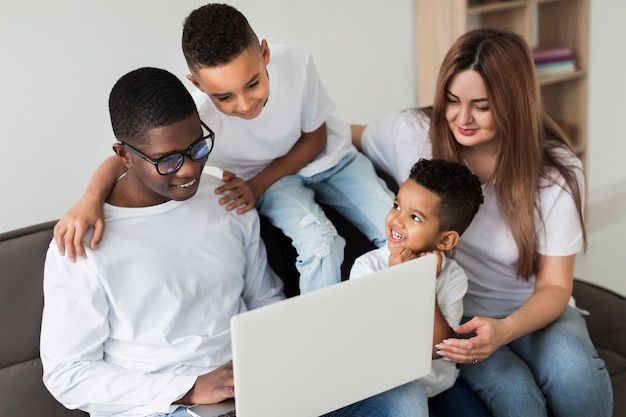 Famiglia multiculturale che guarda insieme su un computer portatile