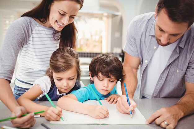 Famiglia scrivendo nel libro, mentre in piedi al tavolo