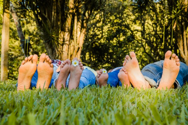 Famiglia sdraiata a piedi nudi sull&#39;erba
