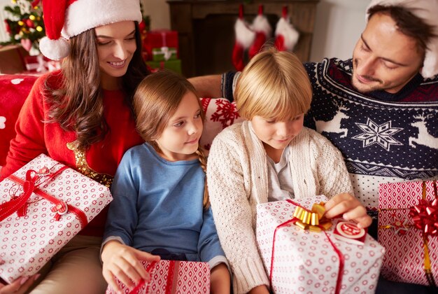 Famiglia seduta a casa con i regali di Natale