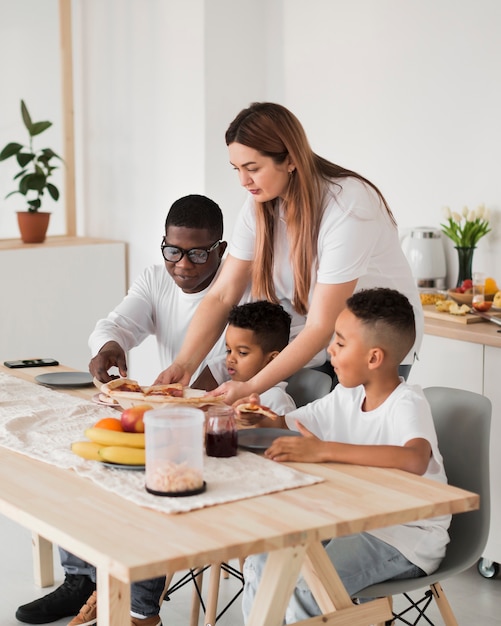 Famiglia si prepara a mangiare la pizza