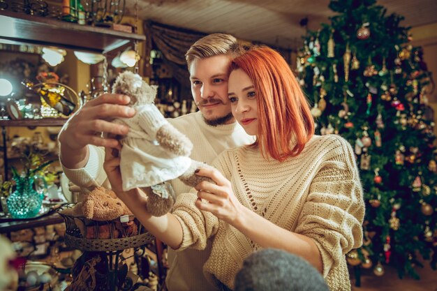 Famiglia sorridente, coppia in cerca di decorazioni per la casa e regali per le vacanze nel negozio di casalinghi