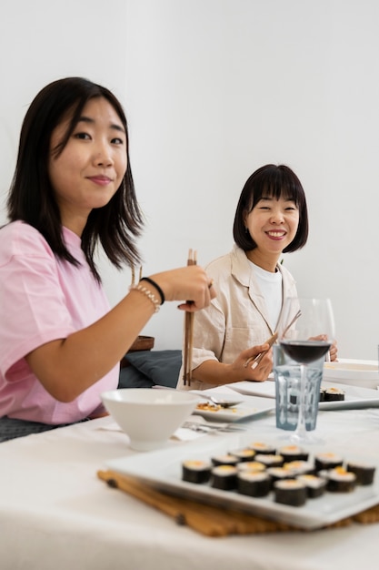 Famiglia sorridente di vista laterale che mangia insieme