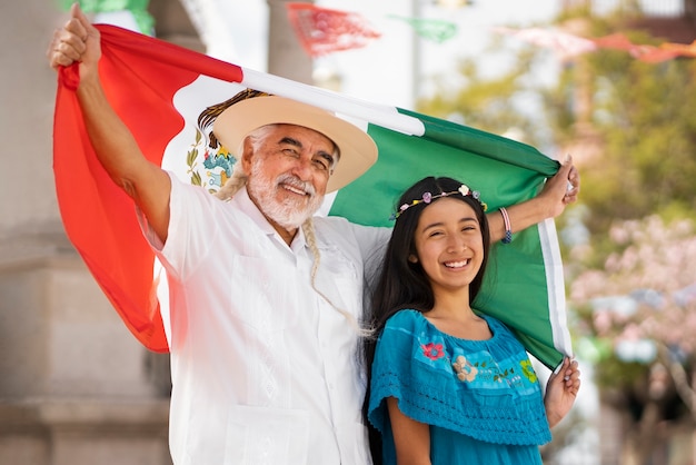 Famiglia sorridente di vista laterale con la bandiera messicana