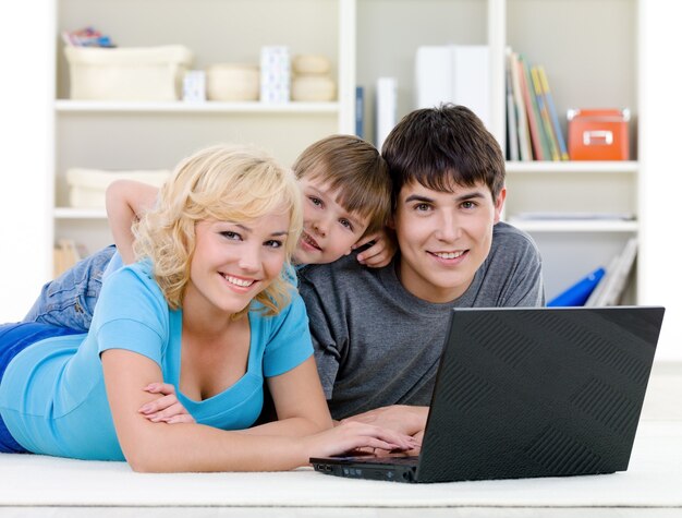 Famiglia sorridente utilizzando laptop