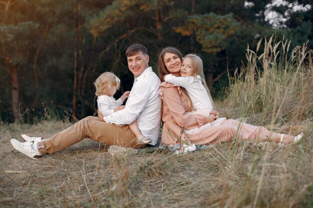 Famiglia sveglia che gioca in un campo di autunno