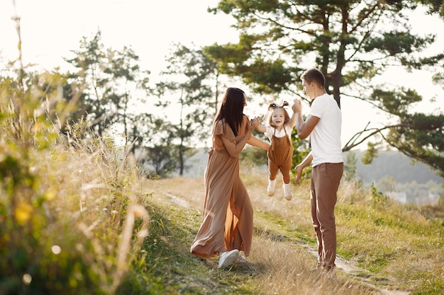 Famiglia sveglia che gioca in un campo di autunno