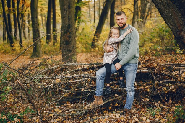 Famiglia sveglia che gioca in un parco di autunno