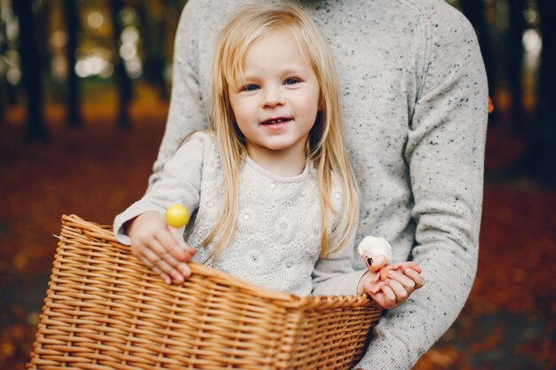 Famiglia sveglia che gioca in un parco di autunno