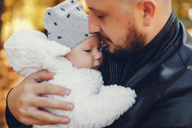 Famiglia sveglia che gioca in un parco di autunno