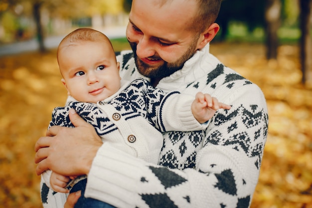 Famiglia sveglia che gioca in un parco di autunno