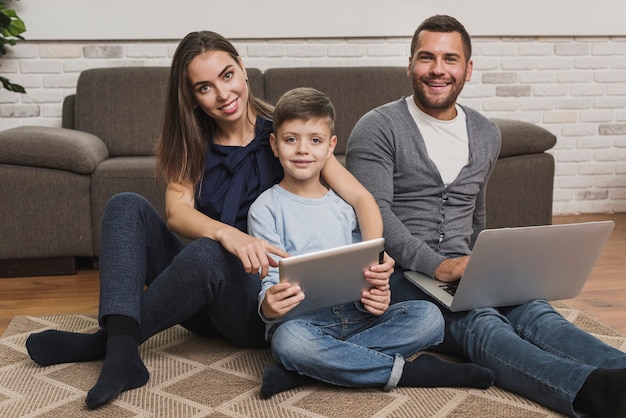 Famiglia vista frontale con laptop e tablet