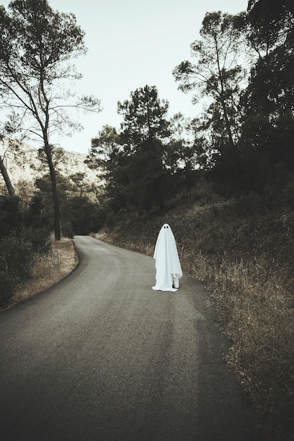 Fantasma che cammina sulla strada di campagna