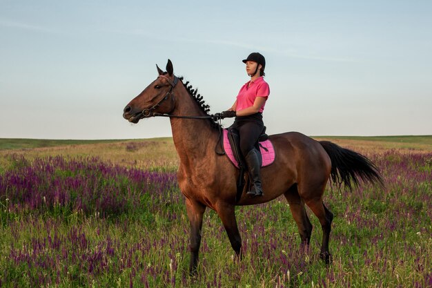 Fantino amazzone in uniforme a cavallo all'aperto