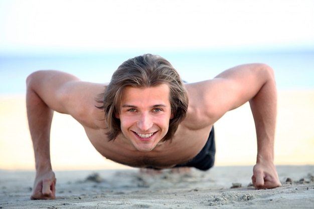 Fare bello dell'uomo spinge aumenta sulla spiaggia