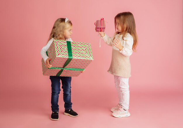 Fare e ricevere regali durante le vacanze di Natale. Gruppo di bambini sorridenti felici che si divertono