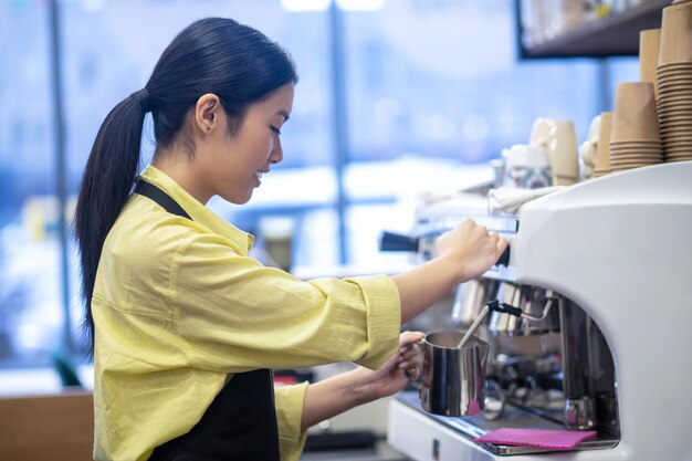 Fare il caffè. Barista che prepara il caffè e mescola il latte