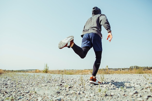 Fare sport. Sprint corridore uomo all'aperto nella natura scenica. Traccia muscolare adatta di addestramento dell'atleta maschio che corre per la corsa di maratona. Uomo atletico in forma sportiva che risolve in abbigliamento di compressione in volata